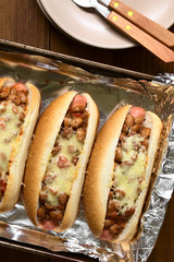 Baked chili hot dogs in baking pan, photographed overhead with natural light