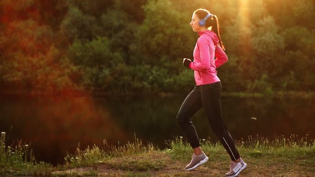 A morning jog in the Park near the pond in the Sunny rays of dawn, the girl is preparing to Mariano and lead a healthy lifestyle