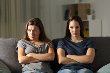 Angry woman looking at camera beside her friend