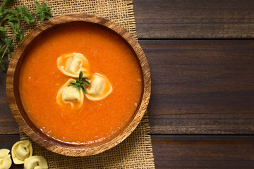 Hausgemachte frische Tomatencremesuppe mit Tortellini und frische Oreganoblätter, fotografiert mit natürlichem Licht (Selektiver Fokus, Fokus auf die Suppe)