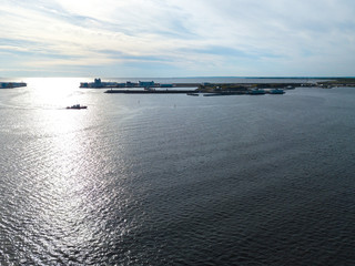 Aerial view of the green red tugboat going along the Finnish Gulf 