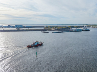 Fototapeta na wymiar Aerial view of the green red tugboat going along the Finnish Gulf 