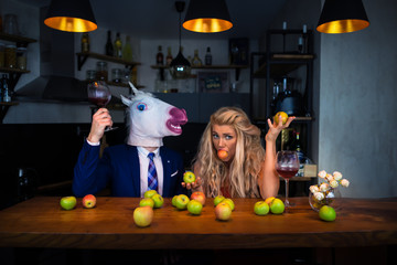 Unusual couple spend time together at the bar counter in stylish apartments with wine and food....