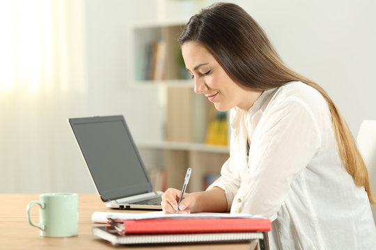 Profile of a student taking notes at home