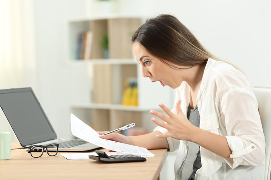 Surprised woman reading bank statement