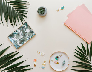 Flat lay composition for social media, bloggers with supplies, notebook and tropical leaves