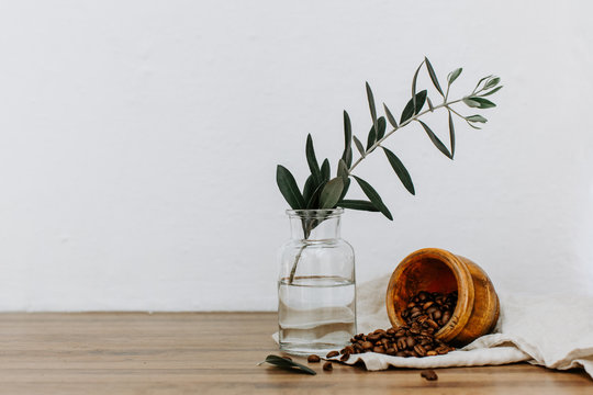 Coffee beens in old mill with olive branch