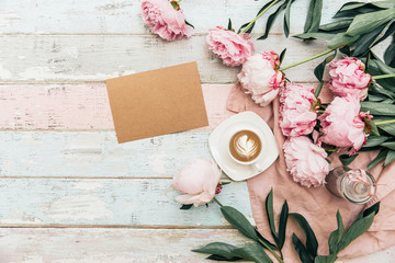 Mock up card. Flat lay cup of coffee and peonies on shabby chic background.