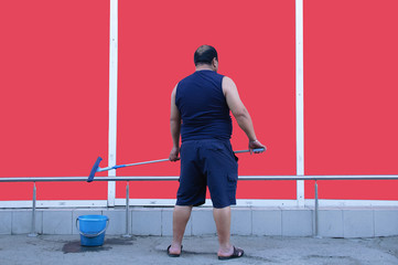 A man is washing the facade of a building.
