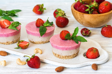 vegan raw strawberry and banana cakes with fresh berries, mint and nuts. healthy food