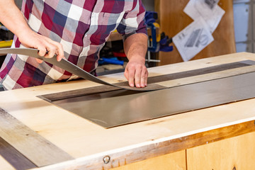 Carpenter doing his job in carpentry workshop. a man in a carpentry workshop measures and cuts laminate