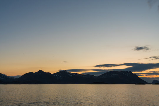 View over the Rorvikstranda beach and Gimsoystraumen fjord near Henningsvaer at Lofoten Islands / Norway at midnight