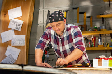 Carpenter doing his job in carpentry workshop. a man in a carpentry workshop measures and cuts laminate