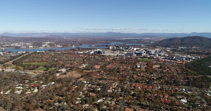 Flying back from Canberra city CBD, lake Burley Griffin and capitol hill with parliament houses over local residential suburbs.
