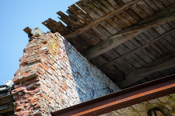 ruined brick wall and wooden roof
