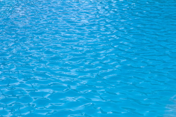 small waves and ripples on the blue water of the swimming pool