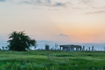 Concrete remains of an old building in the field at sunset