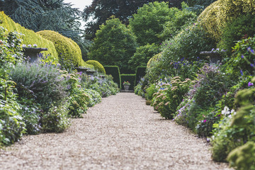Generic empty gravel English garden path in the spring.