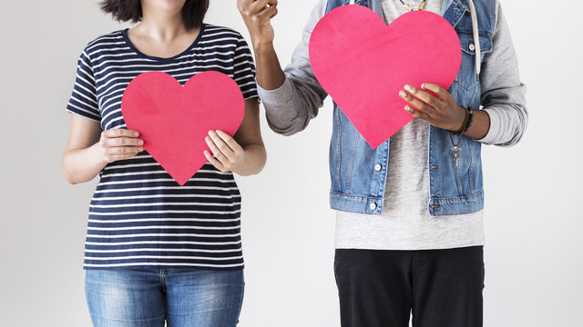 Happy couple holding red heart icons - Powered by Adobe