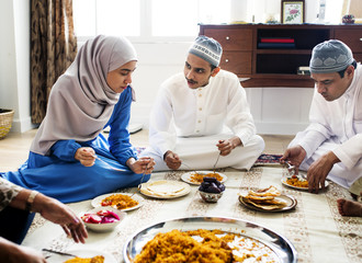 Fototapeta na wymiar Muslim family having dinner on the floor