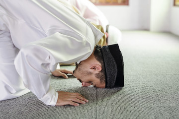 Muslim people praying in Sujud posture - obrazy, fototapety, plakaty