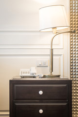 Luxury lamp and telephone on night stand at bedroom hotel