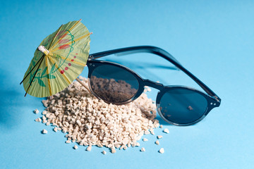 cocktail umbrella, sand and sunglasses