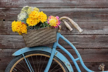 Gordijnen Roestige vintage blauwe fiets met bloemenmand © Kristen