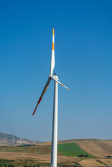 Modern wind farm with big wind turbines towers, source for renewable green energy