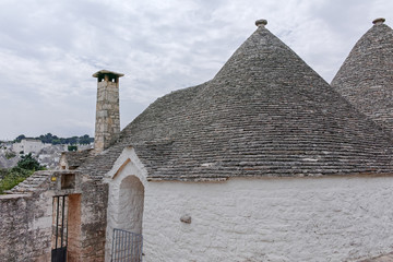 Unique small South Italia city Alberobello with antient stones conical houses trullo, tourist...