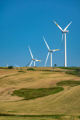 Modern wind farm with big wind turbines towers, source for renewable green energy