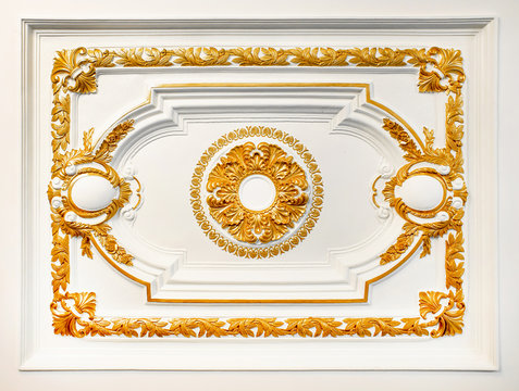 Pattern of gold flower carved on concrete white wall texture background