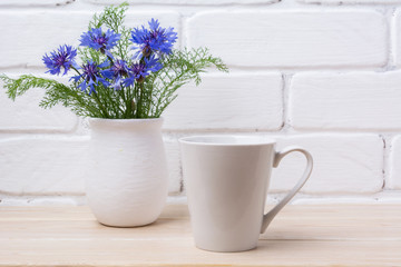 White coffee latte mug mockup with cornflower in rustic vase
