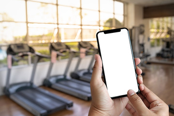 Young man Hand holding smartphone in gym to  fitness phone fitness exercise concept