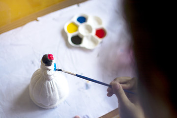 The little child painting plaster doll with blue water colour, practice art concept, selective focus on painting brush