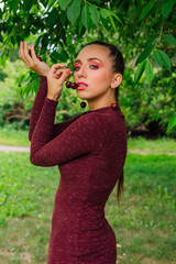 Beautiful young woman with long braid and natural cherry earrings.