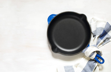 Blue empty cast iron frying pan on white background, top view