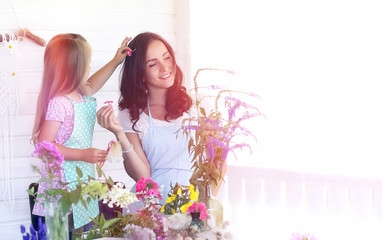 A young girl with a daughter is picking up a bouquet. A young mo