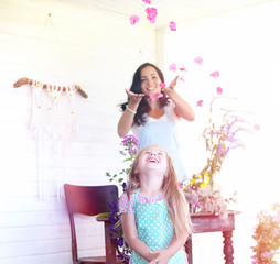 A young girl with a daughter is picking up a bouquet. A young mo
