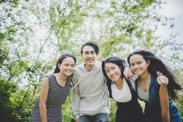 Happy teenage friends smiling outdoors at the park