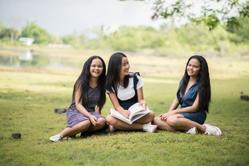 Beautiful students girls group prepare for the exam on the park