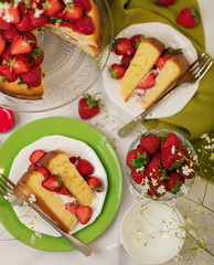 Homemade strawberry cake with cream on a glass stand.