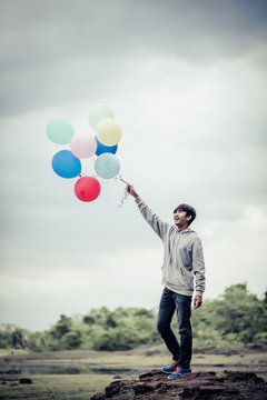 Young Man Hand Holding Colorful Balloons