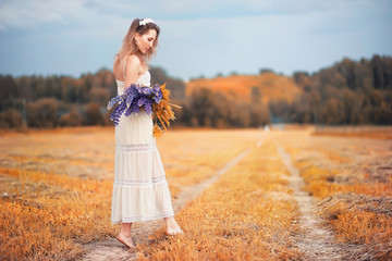 Girl with a bouquet of flowers in autumn