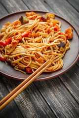 Chinese noodle in sour-sweet sauce and chopsticks on table