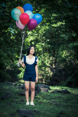 Fototapeta na wymiar Young girl hand holding colorful balloons