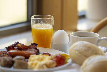 Boiled eggs ,sausages, meat ball, Bread and bacon, Orange juice, Cup of black coffee, Sliced Sweet Pepper and ham on plate, healthy breakfast.