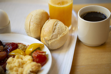 Boiled eggs ,sausages, meat ball, Bread and bacon, Orange juice, Cup of black coffee, Sliced Sweet Pepper and ham on plate, healthy breakfast.