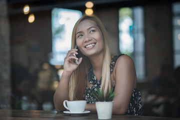 Young woman using and looking at smartphone with feeling happy