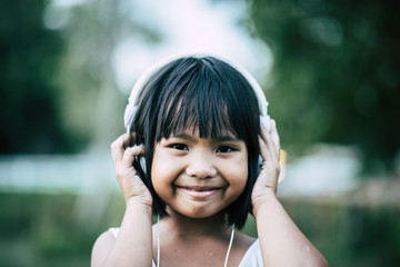 Little girl listening music in the park